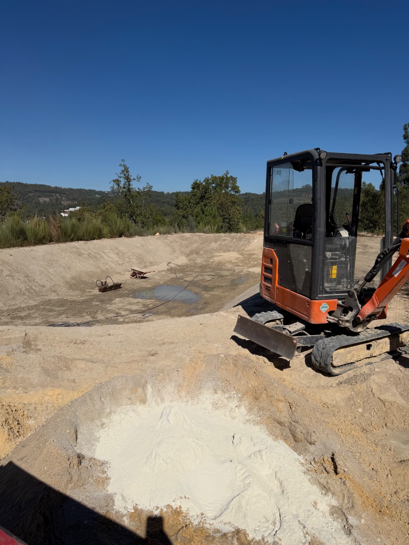 Bentonita junto à escavadora e ao fundo de terra da charca em construção