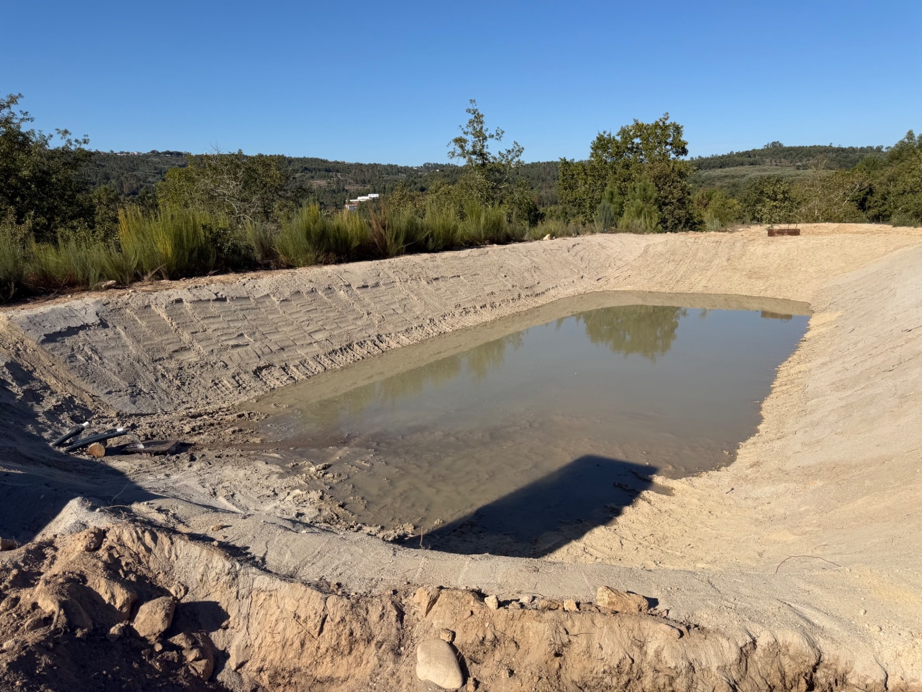 A nossa charca em construção com bentonita, água no fundo e margens de terra natural
